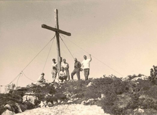 Menschen am Gipfelkreuz auf der Steinplatte