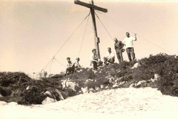 Menschen am Gipfelkreuz auf der Steinplatte